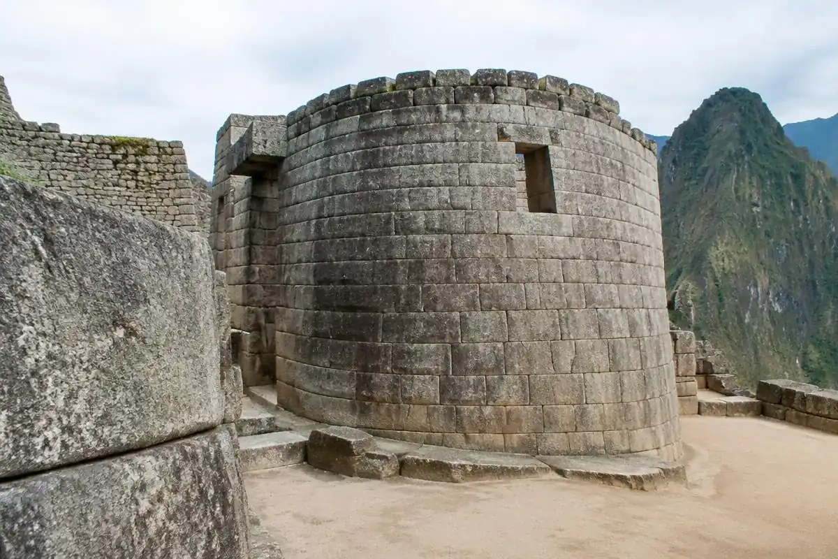 Curved stone tower of the Temple of the Sun inside Machu Picchu