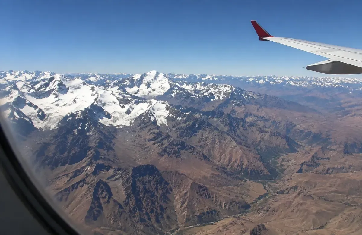 Snowy Andes seen through a plane window on the flight from Lima to Cusco
