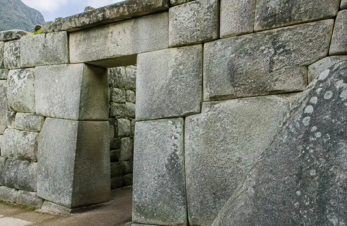 Precisely fitted Inca granite stone wall and trapezoidal doorway at Machu Picchu showing 15th-century masonry
