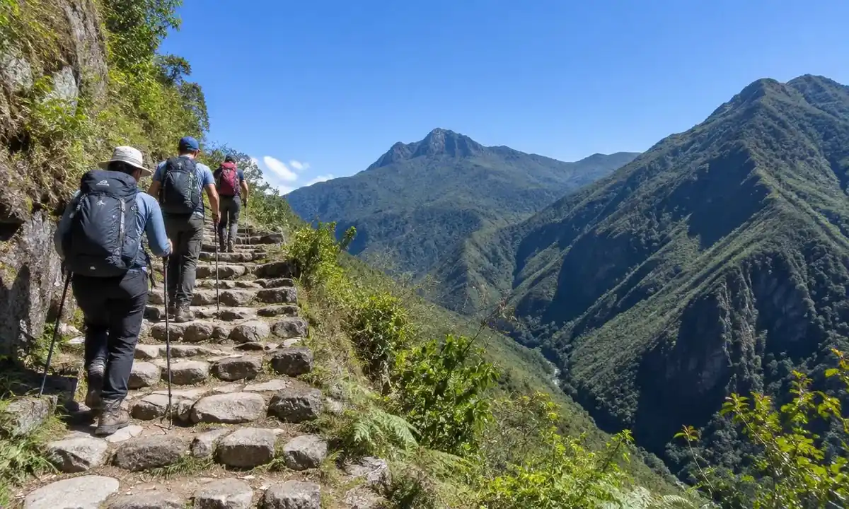 Hikers on Inca Trail stone steps under clear May dry-season skies