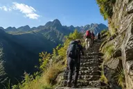 Trekkers with poles climbing steep Inca stone steps on the Inca Trail
