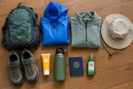 Machu Picchu packing list flat lay with daypack, rain jacket, hiking shoes and passport