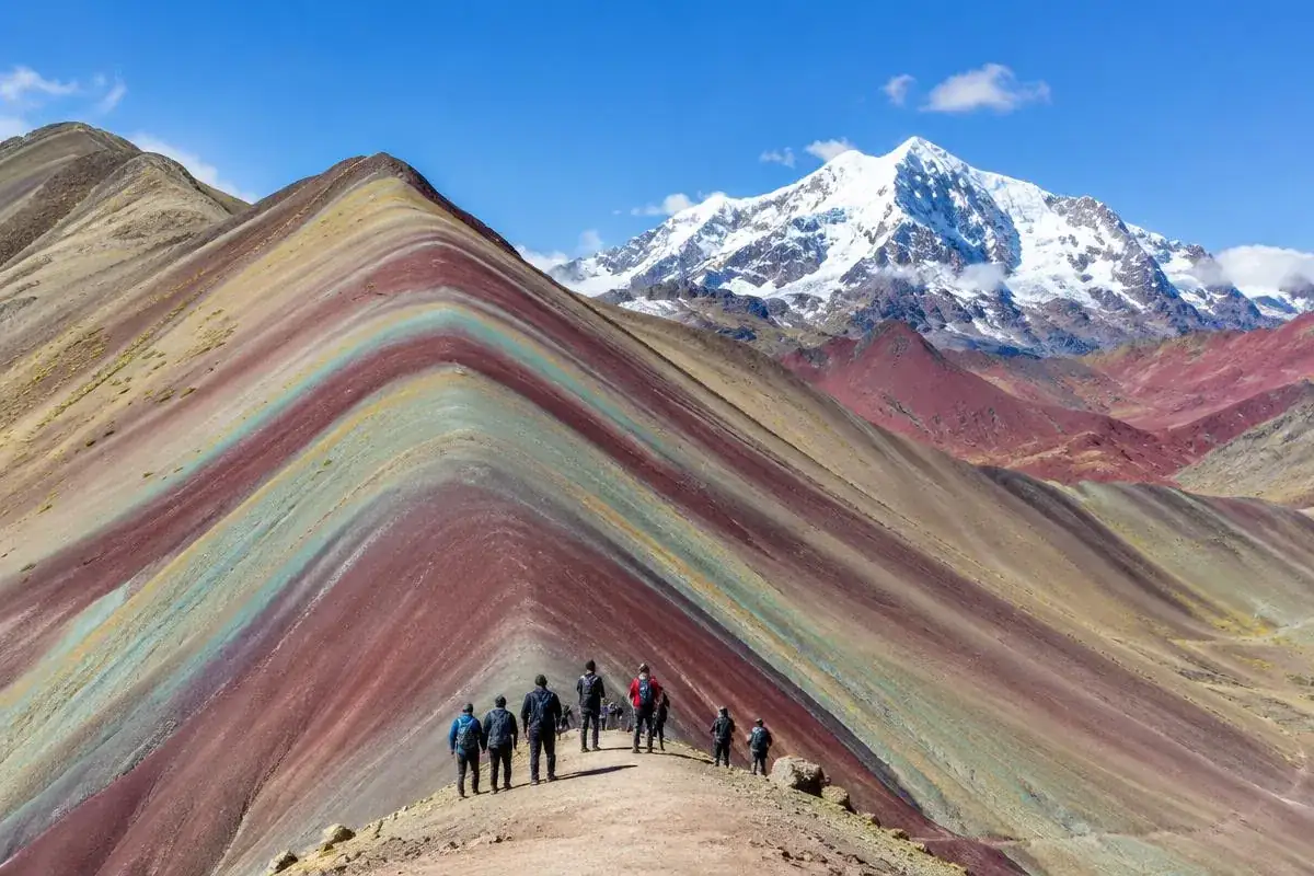 Colorful mineral stripes of Vinicunca rainbow mountain peru with Ausangate peak behind