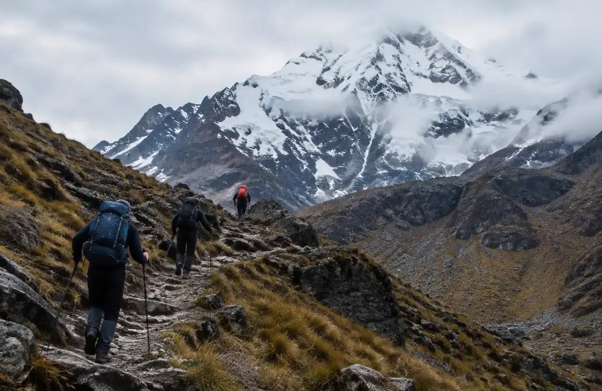 Hikers on steep switchbacks showing salkantay trek difficulty below the snowy peak